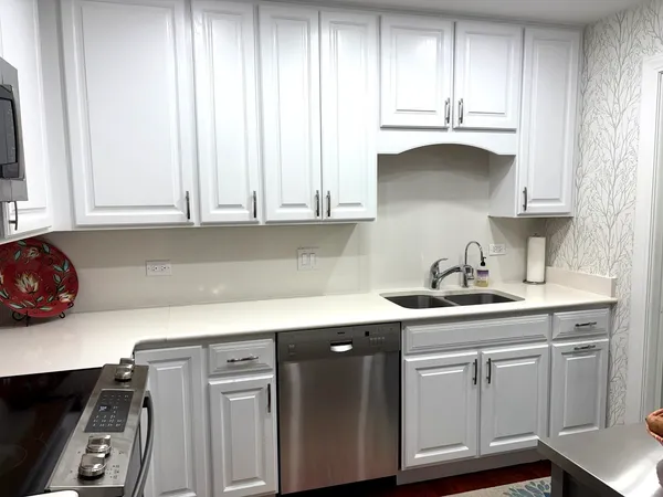 a kitchen with stainless steel appliances white cabinets and a sink