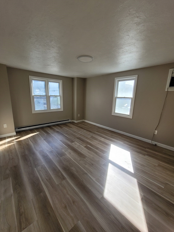 7 Gibbs Street, Unit 7 Worcester, MA 01607 - Photo 12 of 20 a view of an empty room with wooden floor and a window