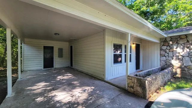 a view of a house with a small yard plants and large tree