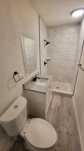a white toilet sitting next to a bathroom sink and a shower