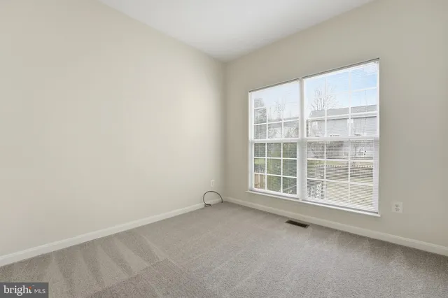 a view of empty room with wooden floor and ceiling fan
