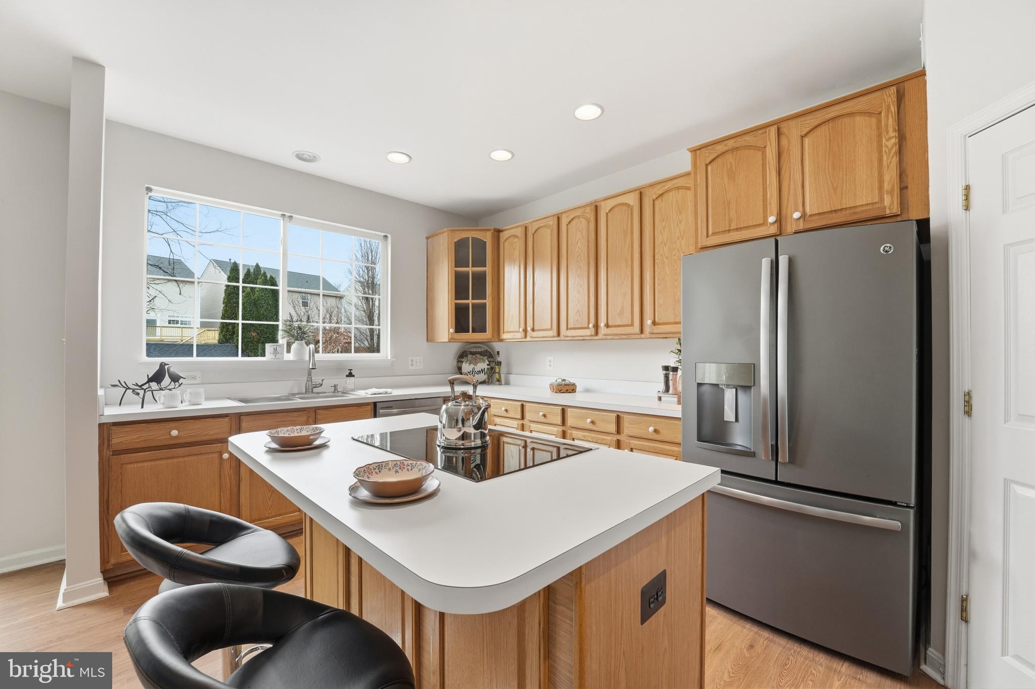 901 Woodcrest Loop Culpeper, VA 22701 - Photo 26 of 61 a kitchen with a sink a refrigerator a stove a kitchen island and chairs in it