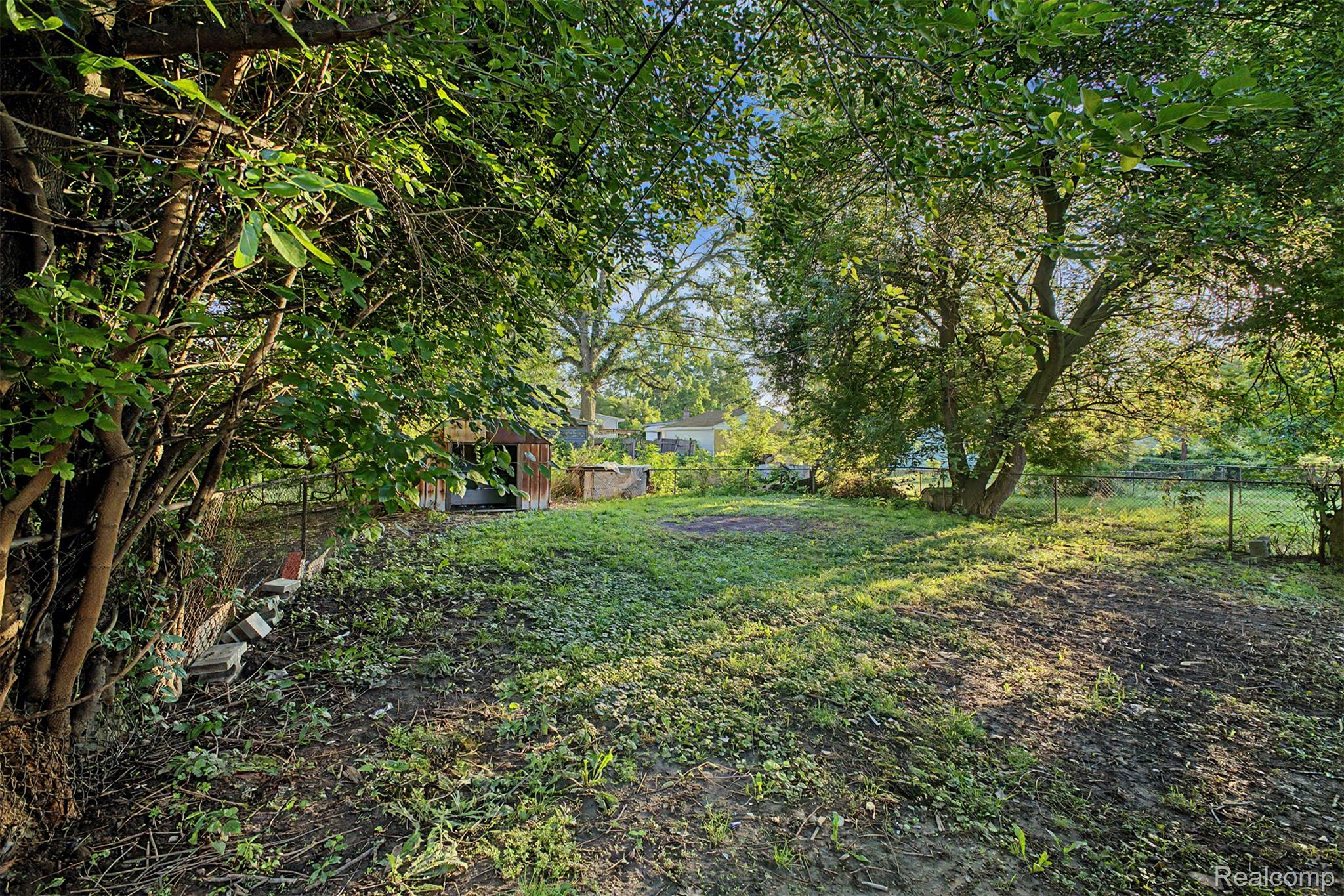 26718 Penn Street Inkster, MI 48141 - Photo 24 of 27 Expansive rear yard featuring mature trees and a chain-link fence