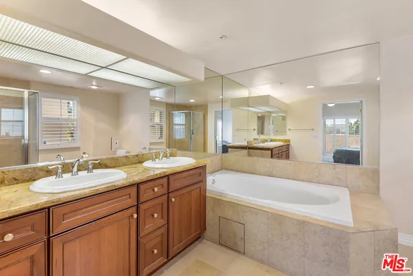 a spacious bathroom with a granite countertop sink mirror and bathtub