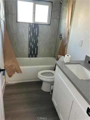 a bathroom with a granite countertop toilet sink and mirror