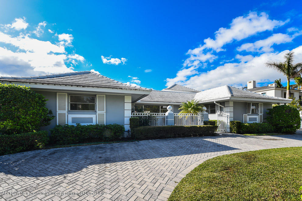 a front view of a house with a yard and potted plants