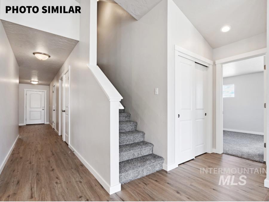925 Twilight Weiser, ID 83672 - Photo 4 of 31 Hallway featuring wood-finish flooring, recessed lighting, and a staircase with carpeted treads