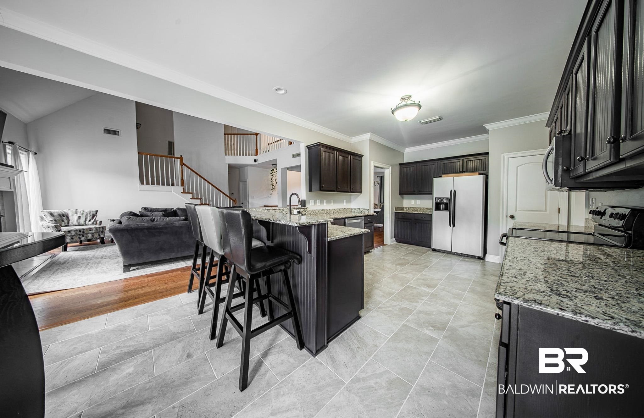 8421 Weatherford Court Daphne, AL 36527 - Photo 14 of 36 Kitchen with ornamental molding, appliances with stainless steel finishes, a peninsula, light stone countertops, and a kitchen bar