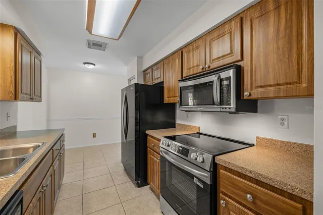 a kitchen with stainless steel appliances granite countertop a stove microwave and refrigerator