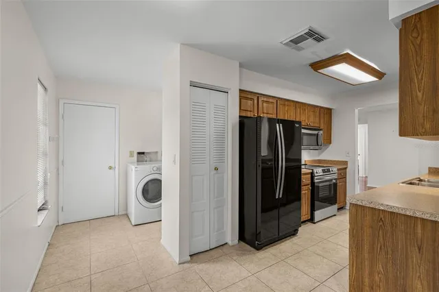 a kitchen with a refrigerator and a stove top oven