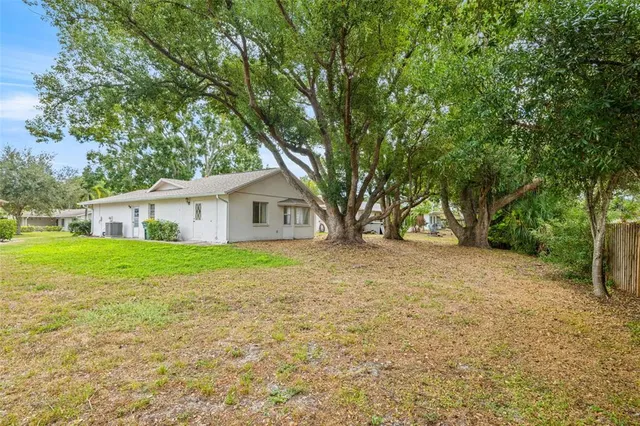 a view of a house with backyard and trees