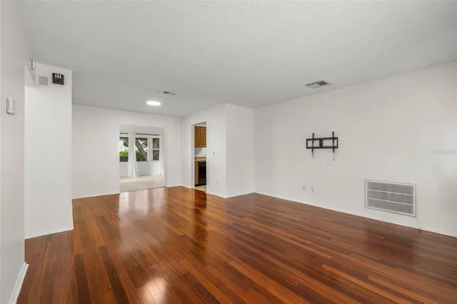 a view of empty room with wooden floor