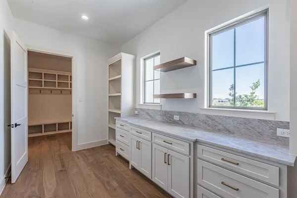 a kitchen with granite countertop white cabinets and wooden floor
