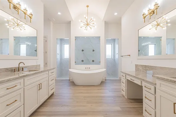 a spacious bathroom with a granite countertop sink a toilet a mirror and shower