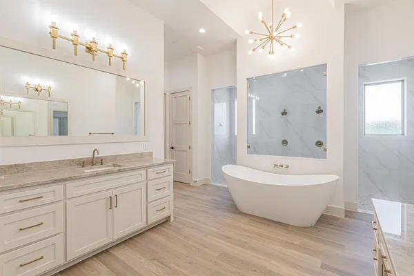 a spacious bathroom with a granite countertop sink a toilet a mirror and shower