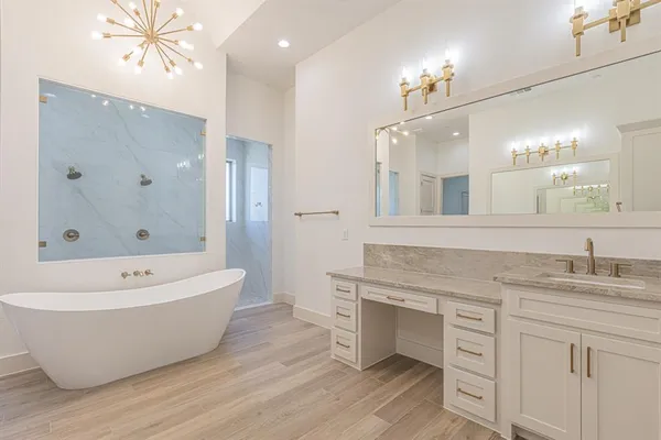 a bathroom with a tub a sink and a mirror