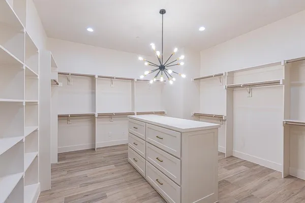 a kitchen with a white island cabinets and wooden floor