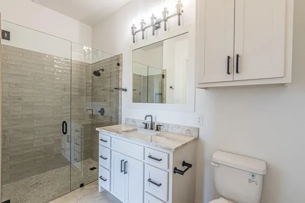 a bathroom with a sink a toilet and shower