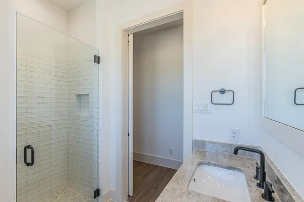 a bathroom with a granite countertop sink a toilet and shower