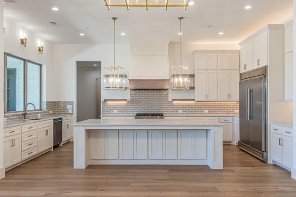 a kitchen with kitchen island granite countertop a stove a sink and a refrigerator