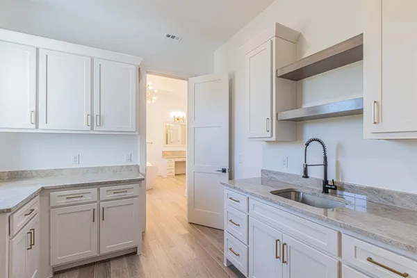 a kitchen with white cabinets white stainless steel appliances and sink