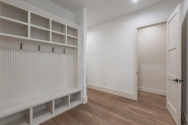 a view of an empty room with wooden floor and closet