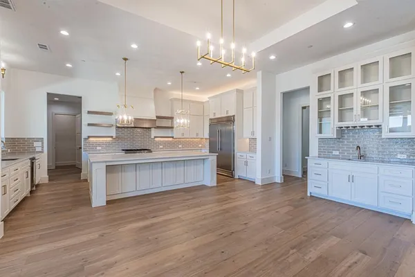 a large kitchen with a center island and stainless steel appliances