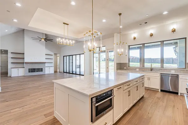 a kitchen with stainless steel appliances granite countertop a kitchen island a stove and a wooden floors