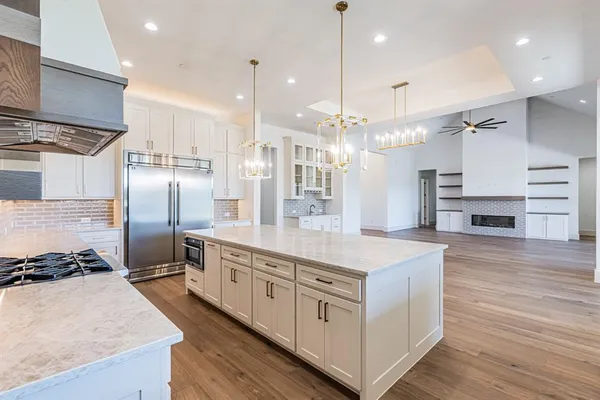 a large kitchen with stainless steel appliances kitchen island granite countertop a stove and a refrigerator