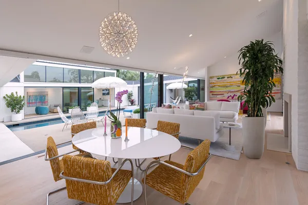 a dining room with furniture a floor to ceiling window and potted plants