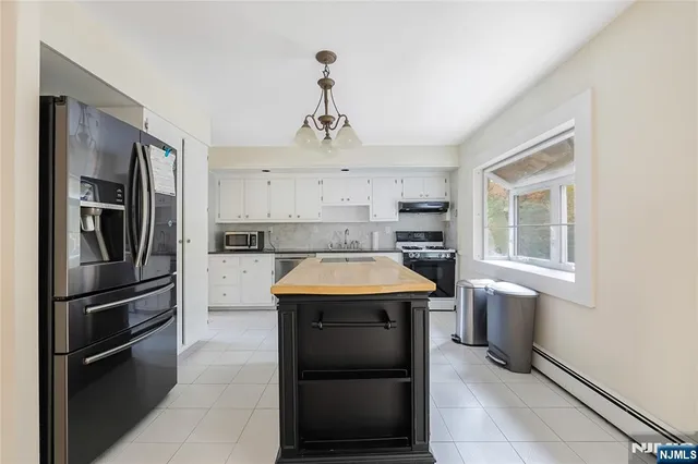 a kitchen with kitchen island granite countertop cabinets and stainless steel appliances