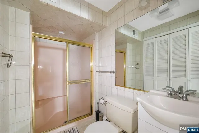 a bathroom with a bathtub shower sink mirror and toilet
