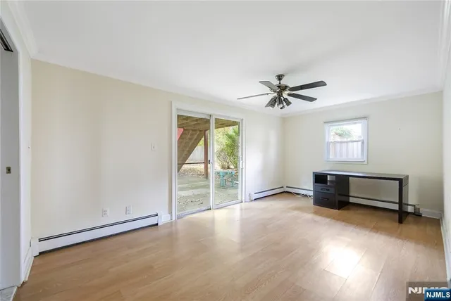 an empty room with windows and fan