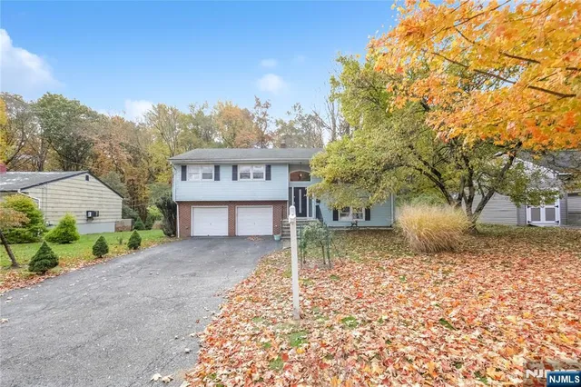 a sign board with a house in the background