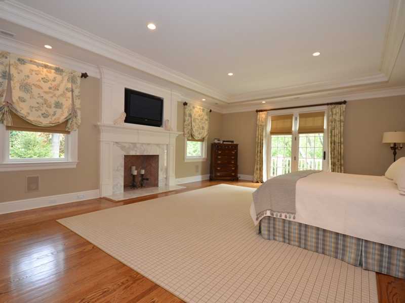 253 Middlesex Road Darien, CT 06820 - Photo 12 of 25 a spacious bedroom with a large bed and a fireplace