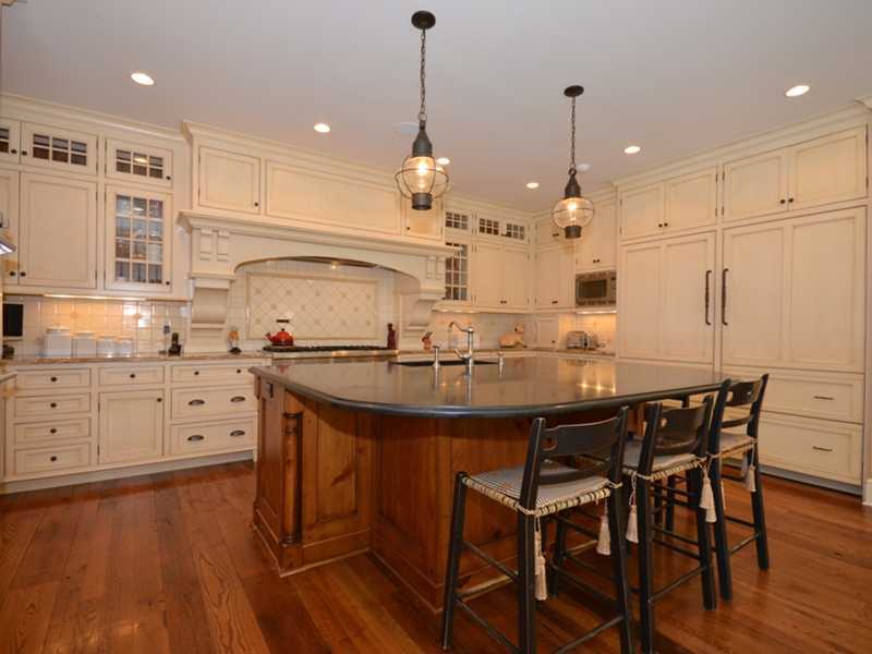 253 Middlesex Road Darien, CT 06820 - Photo 9 of 25 a kitchen with stainless steel appliances kitchen island granite countertop a table chairs sink and cabinets