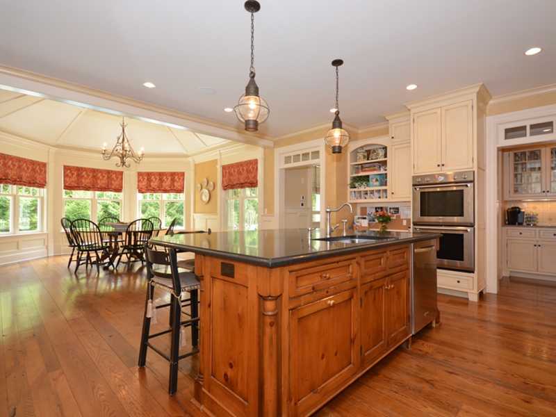 253 Middlesex Road Darien, CT 06820 - Photo 10 of 25 a kitchen with stainless steel appliances granite countertop a stove top oven a refrigerator a dining table and chairs with wooden floor