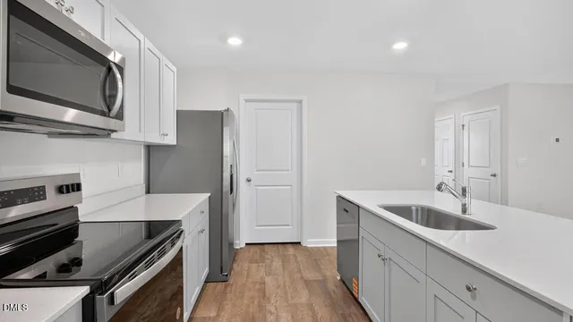 a kitchen with a sink and stainless steel appliances