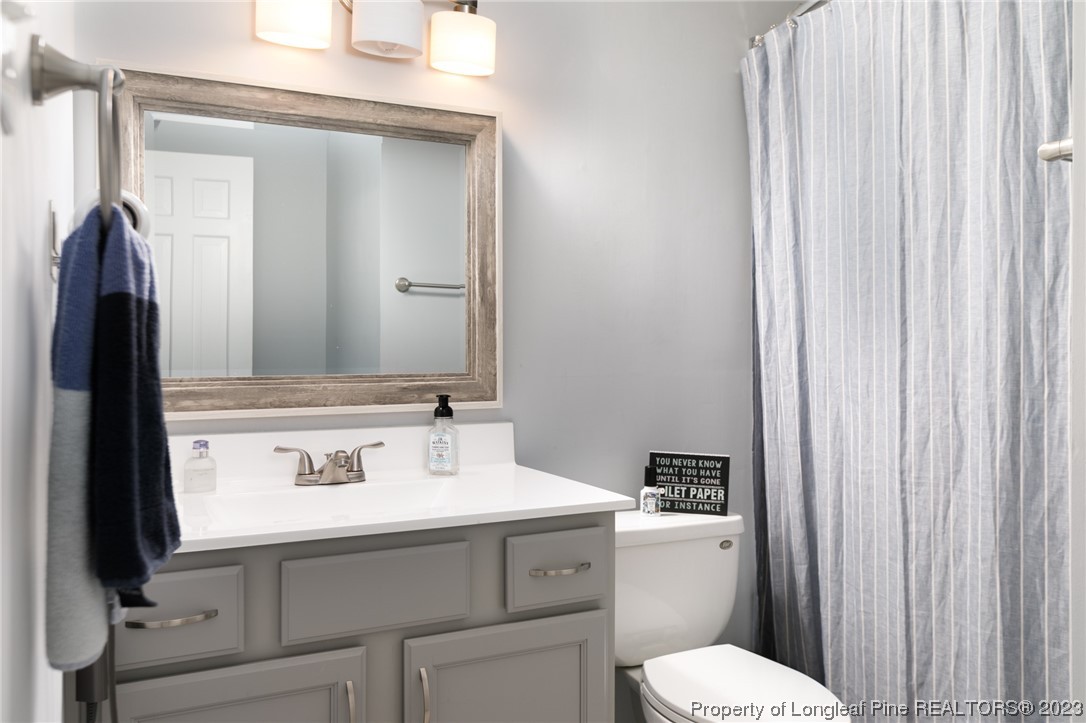 2620 Huntington Road Fayetteville, NC 28303 - Photo 12 of 23 a bathroom with a sink a toilet and mirror