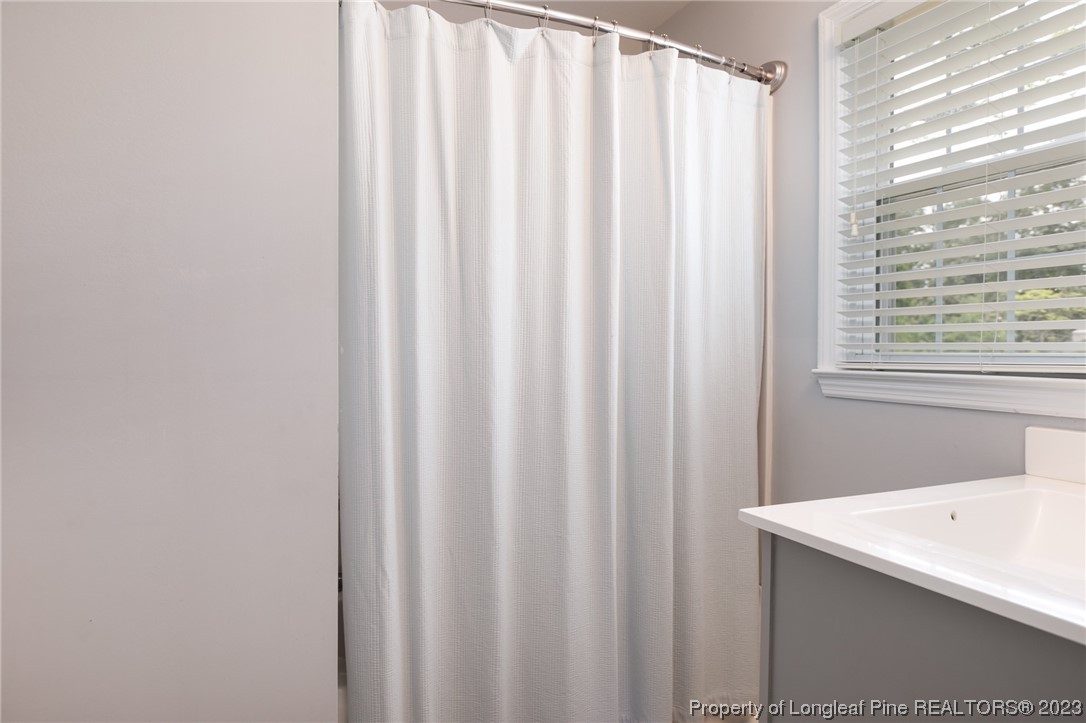 2620 Huntington Road Fayetteville, NC 28303 - Photo 15 of 23 a bathroom with a sink and a shower curtain