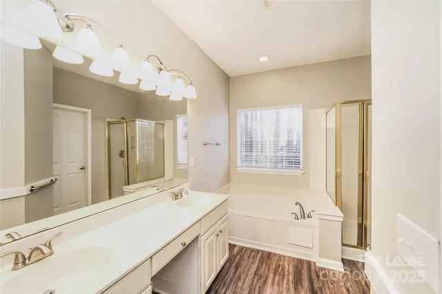 a spacious bathroom with a tub sink and mirror