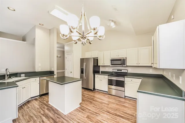 a kitchen with granite countertop a sink and steel appliances