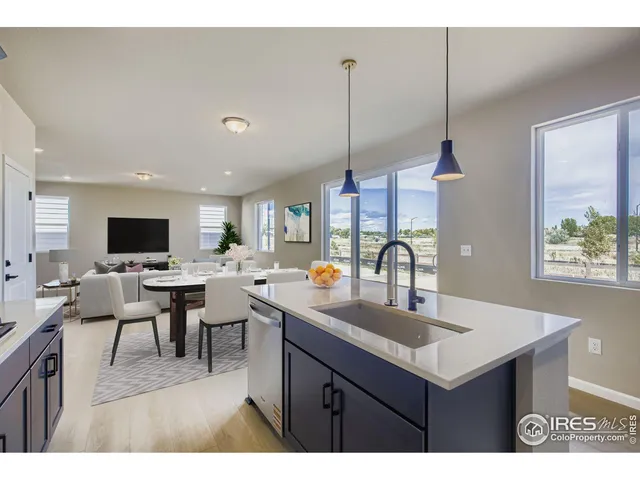 a kitchen with a sink a counter top space and living room view