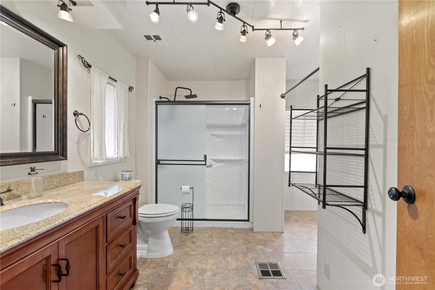 1311 Maple Street, Unit 18 Wenatchee, WA 98801 - Photo 18 of 28 a spacious bathroom with a granite countertop sink a toilet a mirror and shower