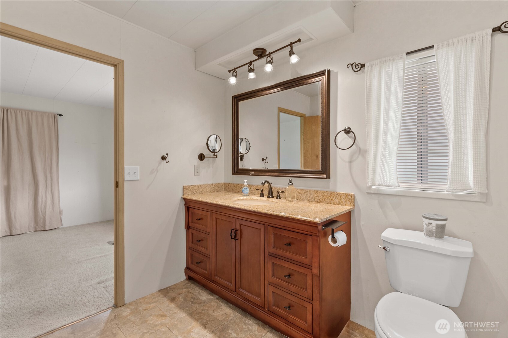 1311 Maple Street, Unit 18 Wenatchee, WA 98801 - Photo 19 of 28 a spacious bathroom with a granite countertop toilet a sink and a mirror
