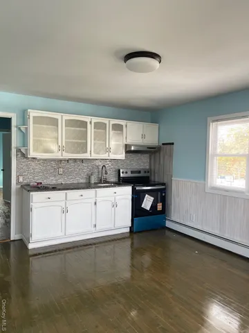 a kitchen with granite countertop a stove and cabinets