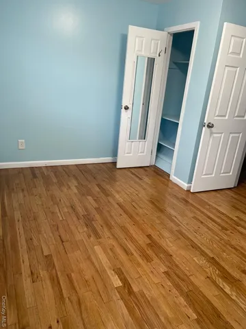 an empty room with wooden floor and door