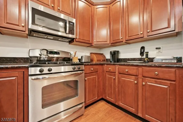 a kitchen with stainless steel appliances granite countertop a stove microwave and cabinets