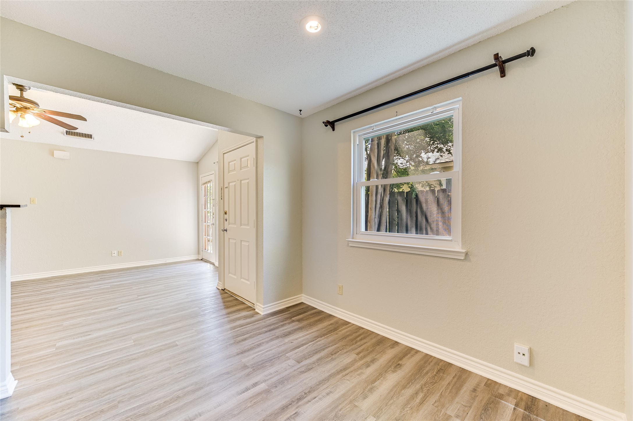 526 Cutty Trail, Unit B Lakeway, TX 78734 - Photo 5 of 10 Open concept living area featuring wood-finish flooring, neutral wall tones, and a window with natural light
