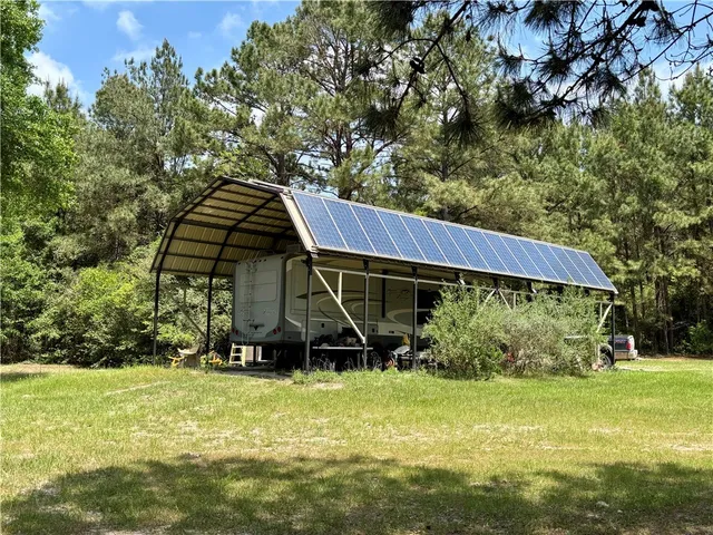a view of a backyard with wooden fence and a bench